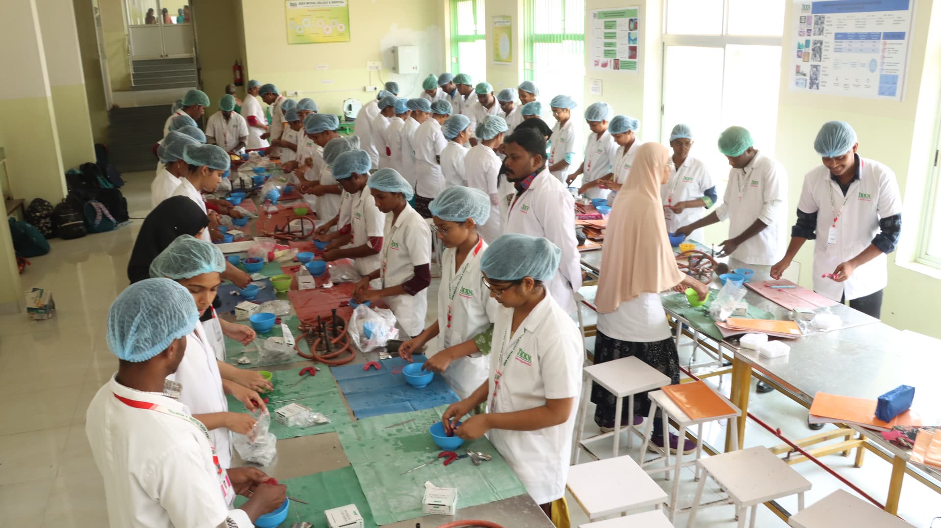 JKKN Dental College preclinical lab with students practicing dental procedures at workbenches